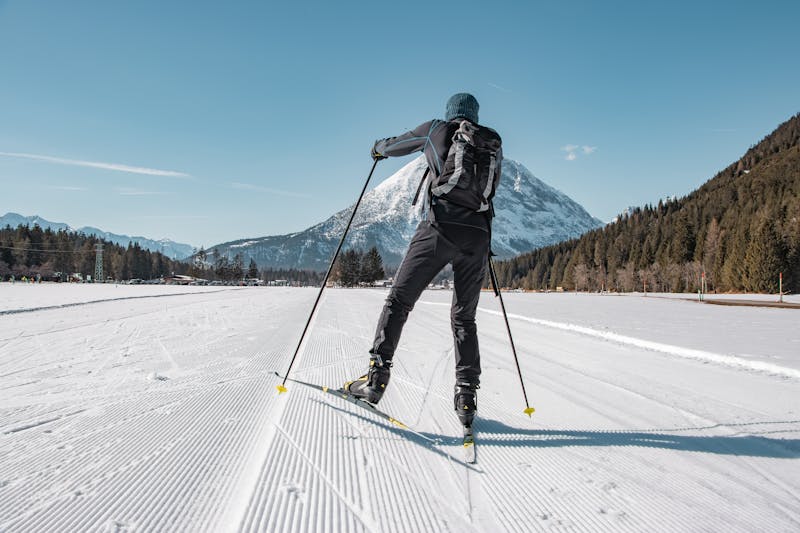 Sci di fondo su pista innevata con montagne
